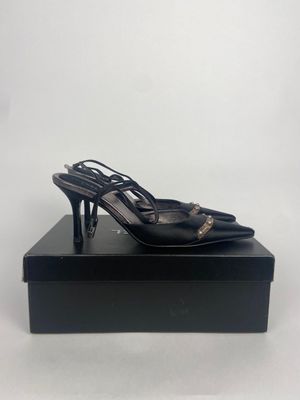 une paire de chaussures à talons hauts noires posée sur une boîte noire