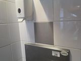 un lavabo équipé d'un distributeur de savon et d'un distributeur de savon fixé au mur