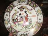 someone is holding a plate with a picture of a woman and a bird on it