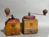 pair of antique coffee grinders with wooden boxes on a white background