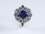 a close up of a blue sapphire and diamond ring on a white background
