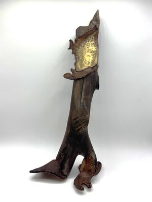 une sculpture en bois représentant un poisson sur laquelle est placée une horloge