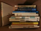 many books stacked on top of each other in a box