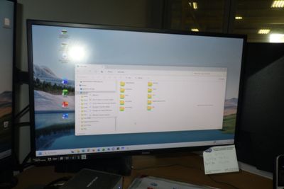 un écran d'ordinateur posé sur un bureau à côté d'un ordinateur portable