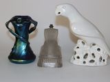 un oiseau blanc perché sur un vase, à côté de deux autres figurines