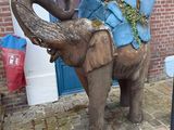 a statue of an elephant with a bag on it ' s back