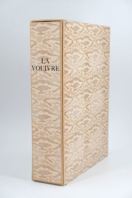 a book with a gold cover sitting on top of a white surface