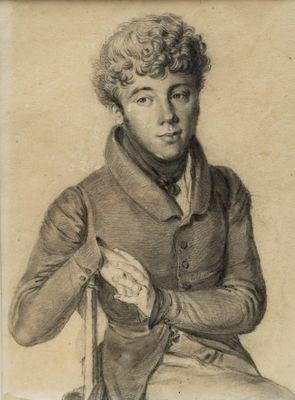 portrait of a man with curly hair sitting in a chair