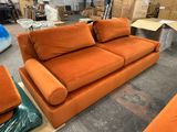 un canapé orange et deux fauteuils dans un entrepôt