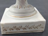 a statue of a woman holding a flower on top of a box