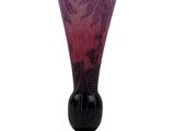 a purple vase sitting on top of a black stand