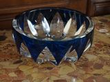 un saladier en verre bleu contenant des cuillères, posé sur une table