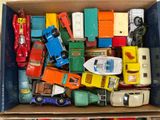 a cardboard box full of toy cars and trucks