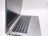 a silver laptop with a black keyboard on a white surface