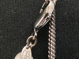 a close up of a chain with a heart charm on it