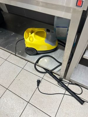 un aspirateur jaune posé par terre près d'une porte