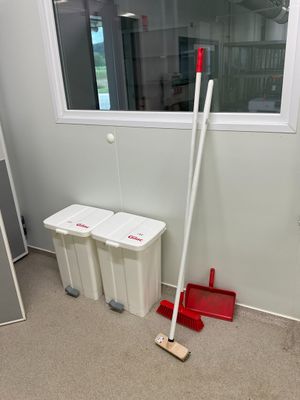 une serpillière et un seau dans un coin de la pièce