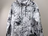 une veste blanche et noire suspendue à un cintre accroché au mur