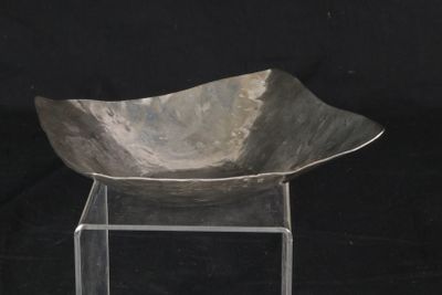 a metal bowl sitting on a clear stand on a black background