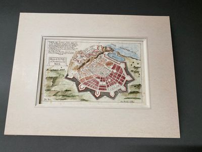 une vieille carte d'une ville, encadrée, posée sur une table