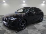 un SUV Audi noir garé sur un sol à damier dans un garage