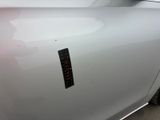 the door handle of a white car with a sticker on it
