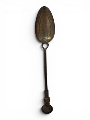 an old spoon with a handle on a white surface