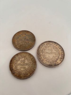 three old coins sitting on top of a white surface