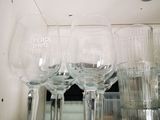 des bouteilles et des verres posés sur une étagère, avec des trous dans le plafond