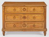 une vieille commode en bois dont les tiroirs sont ornés de sculptures