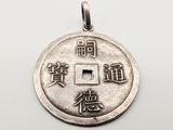 a close up of a silver coin with chinese writing on it