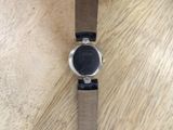 a close up of a watch on a wooden table