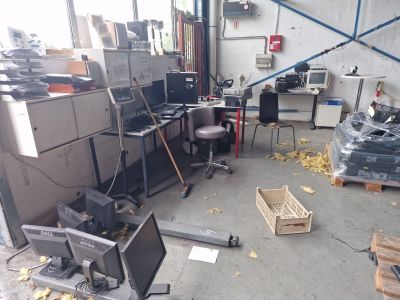 beaucoup de matériel informatique dans une pièce où se trouvent de nombreuses chaises