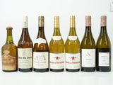 plusieurs bouteilles de vin sont alignées sur une surface blanche