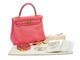 sac à main en cuir rose avec des finitions dorées sur un fond blanc