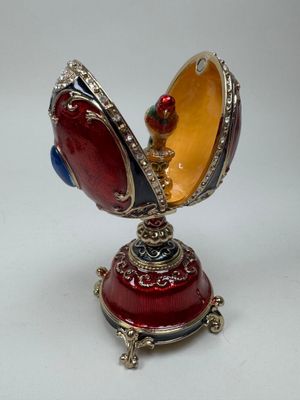 a red, yellow and blue egg shaped box on a stand