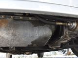 the rear end of a white car with a rusted exhaust pipe