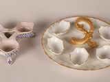a white plate with a gold handle and a white plate with a gold letter on it