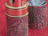 two tins that are sitting next to each other on a red surface