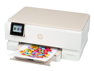 L'imprimante de bureau HP est posée sur une surface blanche, entourée de bonbons colorés.