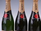 three bottles of champagne sitting next to each other on a table