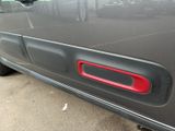 a close up of a car door handle with a red handle