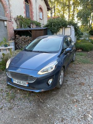 a small blue car parked in front of a house