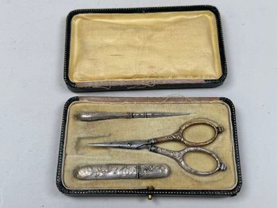 deux paires de ciseaux dans un étui posé sur une table