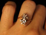 a woman ' s hand with a diamond ring on it