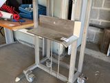 une table sur laquelle est posé un ordinateur portable, dans un garage