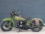 a green motorcycle parked in front of a garage door