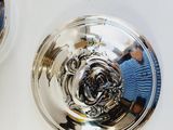 two silver plates with a rose on them on a white table