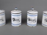 three white and blue canisters with blue designs on them