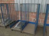 trois cages métalliques surmontées d'un matelas, devant un mur de briques